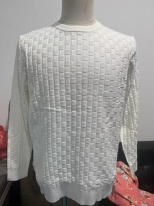 Macro detail of men's white knit sweater featuring textured 3D square knit patterns