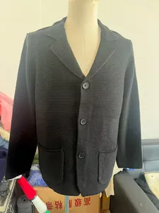 Détail du cardigan noir en maille gaufre avec col à revers et poches avant pratiques