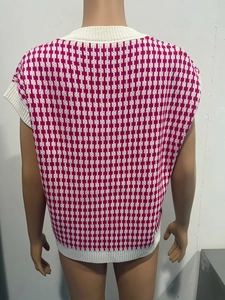 Détail d'un gilet en maille pied-de-poule rose et blanc avec finitions bord-côte au dos