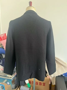 Détail macro du tissu en maille bleu marine texturé au dos de cette veste pour hommes