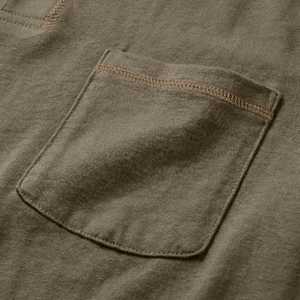 Dettaglio della trama del tessuto e delle cuciture della tasca della maglia Henley oliva