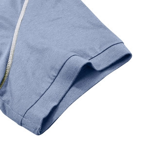 Détail de la manche d'un polo bleu clair avec bord-côte et surpiqûres blanches