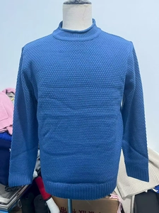 Detail of light blue waffle knit fabric and ribbed crew neck on men's sweater