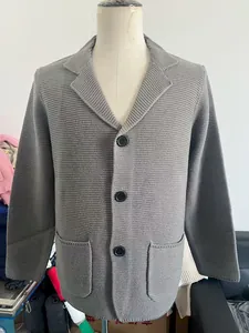 Détail d'un blazer en maille pour homme gris avec col à revers et grandes poches plaquées