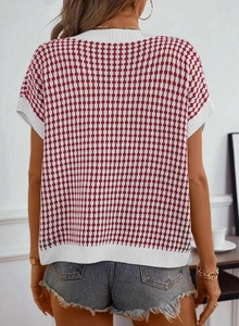Vue détaillée du gilet en tricot à carreaux rouge et blanc avec bords côtelés blancs au col