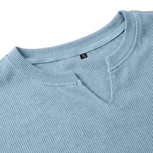 Dettaglio di una t-shirt in maglia celeste con scollo a V e trama di tessuto a coste