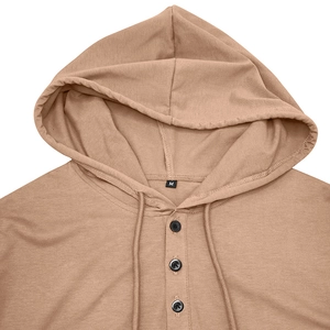 Gros plan détaillé du col henley à capuche kaki avec trois boutons et étiquette de taille M