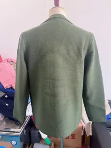 Gros plan d'un cardigan en tricot vert foncé pour hommes montrant les détails de texture