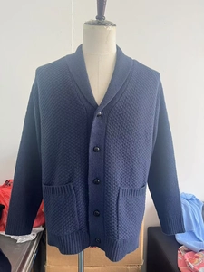 Close-up of a navy men's knit cardigan with shawl collar and textured waffle pattern