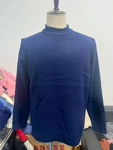 Detail of navy waffle knit texture and ribbed cuffs on men's crew neck sweater