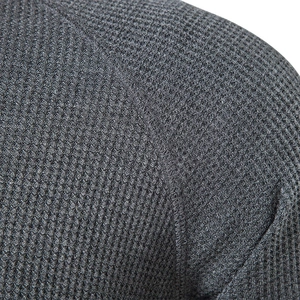 Close-up of deep grey waffle knit fabric with detailed stitching on men's Henley shirt