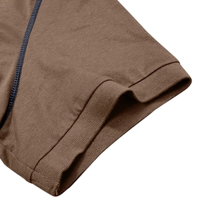 Détail du poignet d'un polo en maille marron avec coutures contrastées et bord-côte