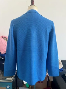 Détail du blazer en maille bleue pour homme montrant la texture alvéolée et le revers