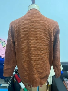 Detail showing caramel waffle knit texture and ribbed hem on a men's casual sweater