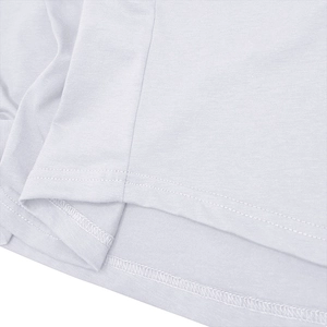 Détail macro de la double couture de qualité sur un t-shirt de sport en coton blanc pour hommes