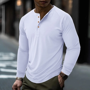Detail of raglan sleeves and three orange buttons on a long sleeve Henley shirt