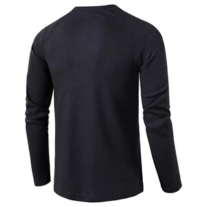 Detail view of the waffle fabric texture and raglan sleeves on men's long sleeve henley shirt