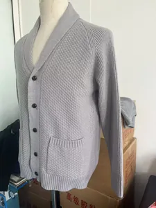 Detail view of mid-grey knit cardigan with shawl collar and textured diamond pattern