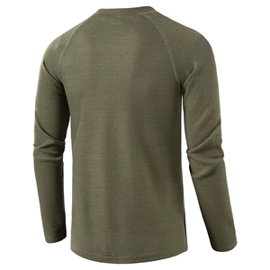 Detail view showing the waffle knit texture and raglan sleeve design of a green long-sleeved shirt