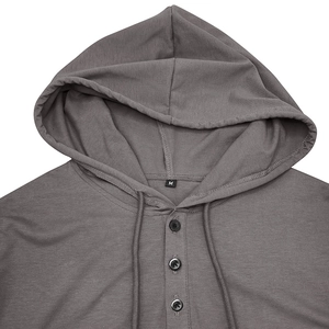 Détail d'un sweat à capuche henley gris foncé avec cordon de serrage et boutons