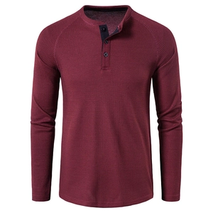 Detailed view of the burgundy waffle knit fabric and buttoned Henley neckline on men's shirt