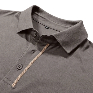 Detail of dark gray polo shirt neckline with golden contrast stitching and S size label