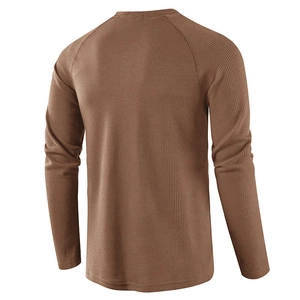 Macro detail of brown waffle knit fabric on the back of men's long sleeve henley shirt