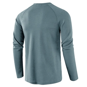 Detailed close-up of grey-blue waffle knit fabric texture on a long-sleeve henley shirt