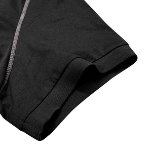 Détail du poignet d'un polo noir avec bord-côte et surpiqûres grises contrastées