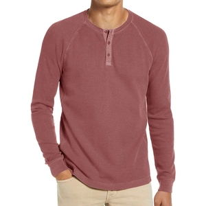 Detail view of waffle texture fabric and three-button placket on men's dusty pink Henley shirt