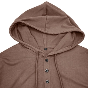 Détail d'un sweat à capuche en tricot marron avec col Henley à trois boutons et cordons