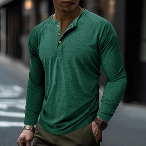 Close-up of dark green Henley shirt with three wood buttons and raglan sleeves detail