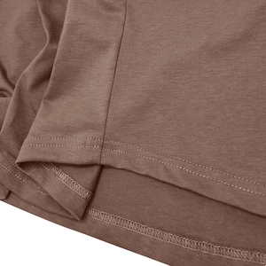 Vue macro de la couture à double aiguille sur l'ourlet du t-shirt en tricot marron