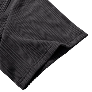 Macro shot of ribbed fabric texture and double-needle stitching on the black polo shirt cuff