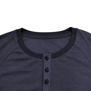Detail of dark grey waffle knit fabric with a three-button Henley neck and black ribbed collar