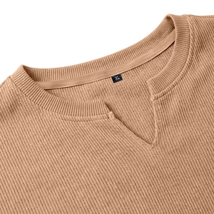 Dettaglio dello scollo a V su una maglia a coste marrone che mostra la trama del tessuto