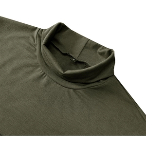 Détail d'un t-shirt col montant vert olive montrant les coutures et l'étiquette