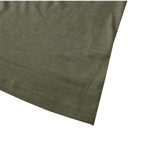 Détail de l'ourlet du t-shirt vert olive montrant la précision de la double couture