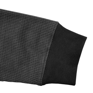 Detail of dark grey waffle knit fabric with black ribbed cuff on long sleeve Henley shirt
