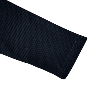 Detailed macro view of navy waffle knit texture and reinforced cuffs on long sleeve polo shirt