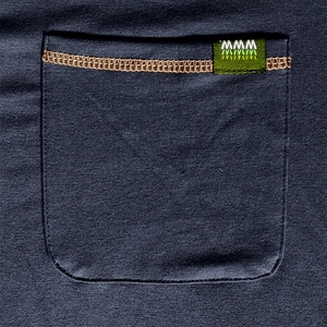 Detail of the knit pocket with brown stitching and small green logo tag on a navy shirt