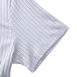 Detailed close-up showing the white ribbed fabric texture and flat double-needle sleeve stitching
