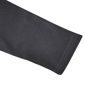Detailed close-up of dark grey waffle knit texture and stitching on men's long sleeve polo