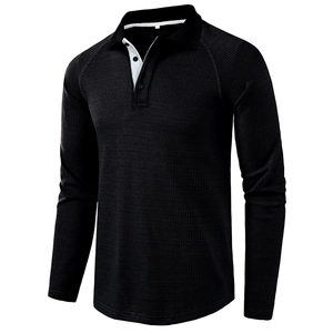 Close-up of black waffle knit texture on men's long sleeve polo shirt with contrast collar