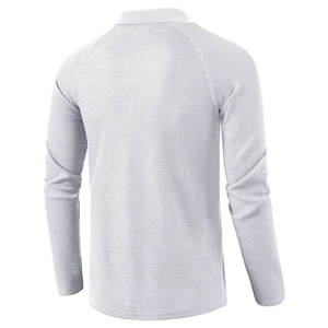 Detail view of white long-sleeve polo shirt with waffle knit fabric texture and raglan sleeves