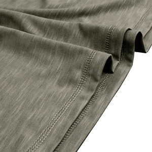 Detail of olive green slub cotton fabric with double-stitched hem and knit texture