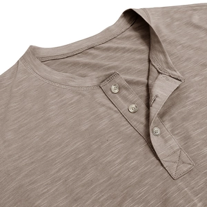 Close-up of the three-button placket and slub cotton texture on a men's brown Henley shirt