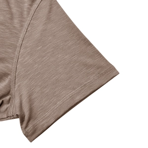 Détail de l'ourlet et de la texture chinée du tissu sur un t-shirt Henley marron