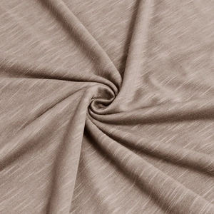 Gros plan sur le tissu en maille gaufrée marron montrant la texture douce et le drapé fluide
