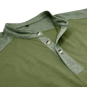 Dettaglio dello scollo Henley con tre bottoni marmorizzati e cuciture a contrasto sul verde